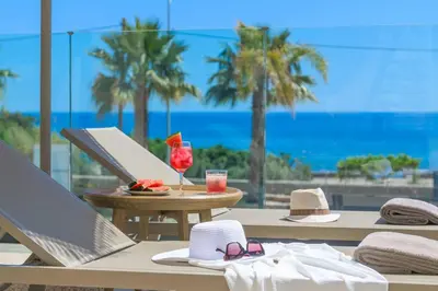 a table with a plate of food and a drink on a beach at Villa Helios in Kiotari