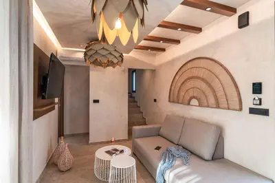 a living room with a couch and a chandelier at Villa Helios in Kiotari
