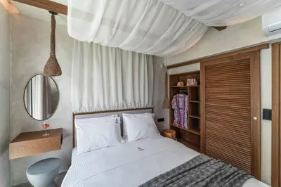 a bedroom with a white bed and a mirror at Villa Helios in Kiotari