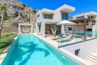 a villa with a swimming pool and a house at Villa Helios in Kiotari