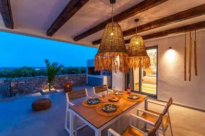 a dining room with a table and chairs with a view at Villa Paparouna in Gennadi