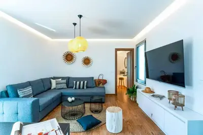a living room with a blue couch and a tv at Villa Paparouna in Gennadi