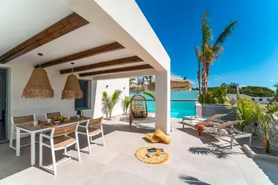 a patio with a table and chairs and a pool at Villa Paparouna in Gennadi