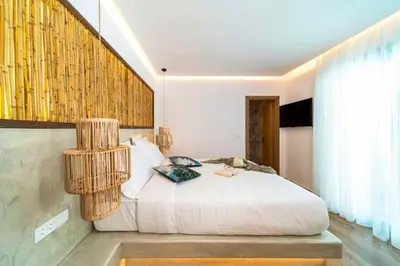 a bedroom with a white bed and a large window at Villa Paparouna in Gennadi