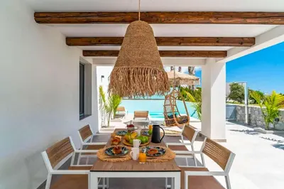 a dining room with a table with food and a chandelier at Villa Paparouna in Gennadi