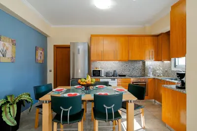 a kitchen with a wooden table and chairs at Katerina Apartment in Afantou