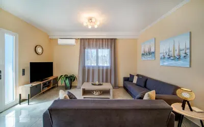 a living room with a couch and a tv at Katerina Apartment in Afantou