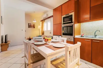 a kitchen with a table with chairs and a microwave at Louis House in Rhodes Town