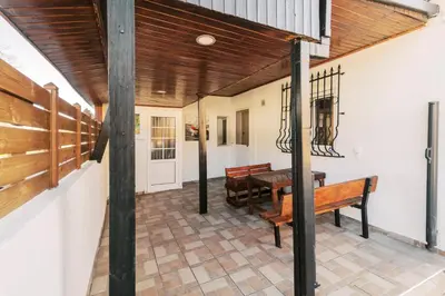 a porch with a bench and a table at Louis House in Rhodes Town
