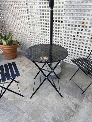 a glass table and two chairs on a patio at 1919's Studio in Asklipiḯon