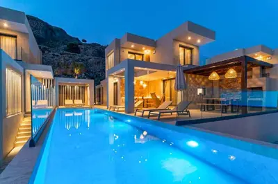 a villa with a swimming pool at night at Villa Ouranos in Kiotari