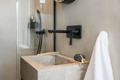 a bathroom with a stone sink and a shower at Villa Ouranos in Kiotari