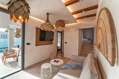 a living room with a couch and a tv and a table at Villa Ouranos in Kiotari