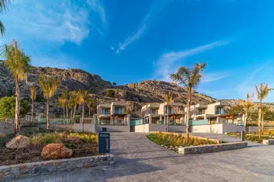 a resort with palm trees and a mountain at Villa Ouranos in Kiotari