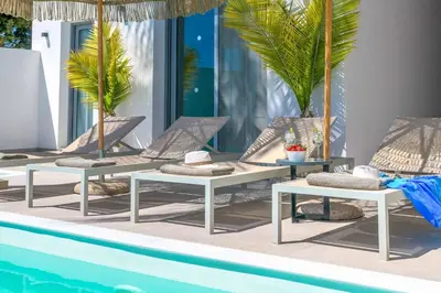 a group of lounge chairs next to a pool at Villa Elia Gennadi in Gennadi
