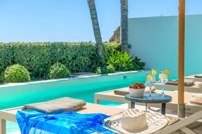 a patio with a table and chairs next to a pool at Villa Elia Gennadi in Gennadi