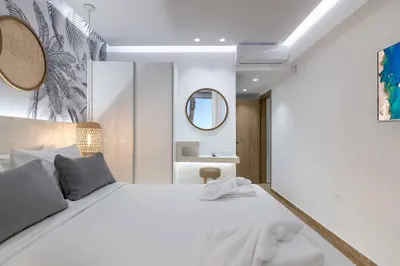 a bedroom with a large white bed and a mirror at Villa Elia Gennadi in Gennadi