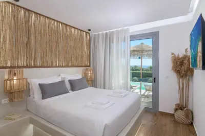 a bedroom with a white bed with a view of the ocean at Villa Elia Gennadi in Gennadi