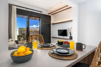a table with plates and bowls of fruit on it at Villa Kiotari Sky in Kiotari