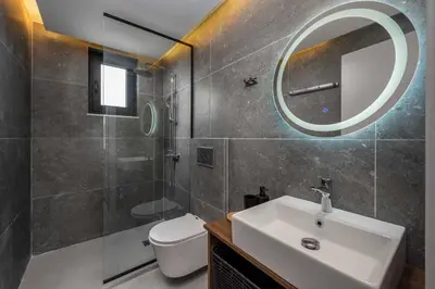 a bathroom with a sink and a toilet and a mirror at Villa Kiotari Sky in Kiotari