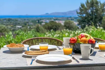 a table with plates of food and a bowl of fruit at Massari Hills Villa 8 in Malona Village