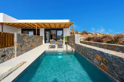 a swimming pool in a house with a stone wall at Villa Kiotari Sun in Kiotari