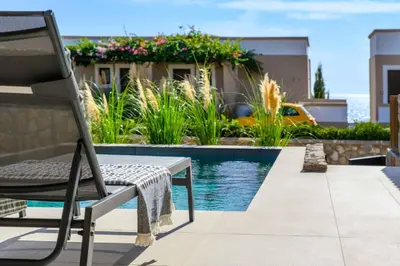 a chair sitting next to a swimming pool at Villa Kiotari Sun in Kiotari