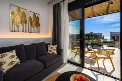 a living room with a couch and a sliding glass door at Villa Kiotari Sun in Kiotari