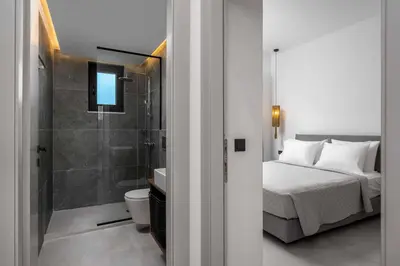 a bedroom with a bed and a bathroom with a shower at Villa Kiotari Sun in Kiotari
