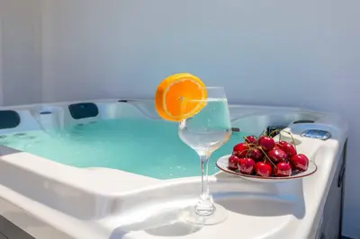 a glass of wine and a plate of fruit in a tub at Villa Filia in Ialyssos