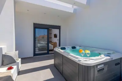 a bathroom with a tub with two glasses in it at Villa Filia in Ialyssos