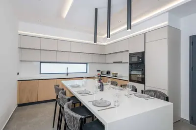 a kitchen with a long white table and chairs at Villa Filia in Ialyssos