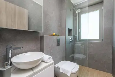 a bathroom with a sink and a glass shower at Villa Panaxia Votsalo in Theologos