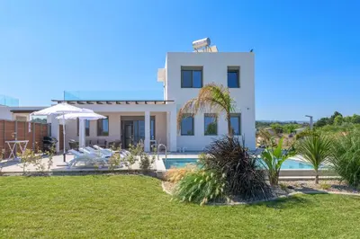 a villa with a swimming pool and a house at Villa Panaxia Votsalo in Theologos