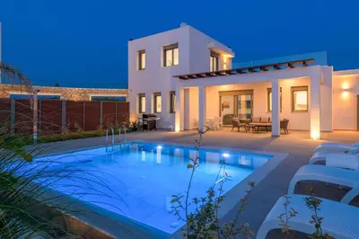 a villa with a swimming pool in front of a house at Villa Panaxia Kohille in Theologos