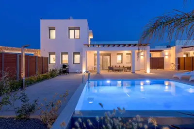 a villa with a swimming pool in front of a house at Villa Panaxia Kohille in Theologos