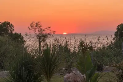 a sunset over the ocean with the sun in the horizon at Villa Panaxia Kohille in Theologos