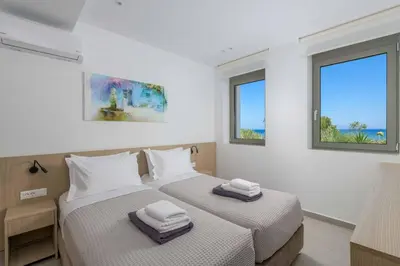 two beds in a room with two windows at Villa Panaxia Kohille in Theologos