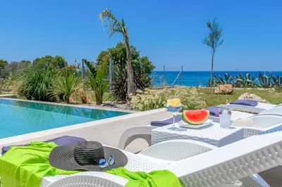 a table with a bowl of watermelon on it next to a pool at Villa Panaxia Keema in Theologos