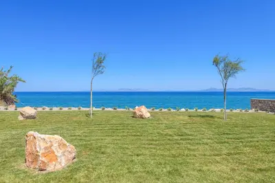 a large rock in a field next to the ocean at Villa Panaxia Keema in Theologos