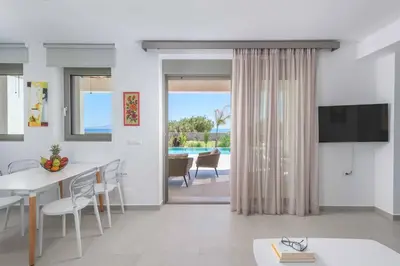 a living room with a dining table and a television at Villa Panaxia Keema in Theologos