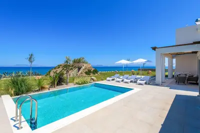 a villa with a swimming pool and the ocean at Villa Panaxia Keema in Theologos