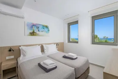 two beds in a room with two windows at Villa Panaxia Keema in Theologos