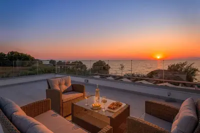 a patio with a view of the ocean at sunset at Villa Panaxia Keema in Theologos