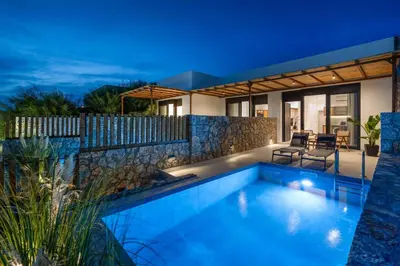 a swimming pool in front of a house at night at Villa Kiotari Star in Kiotari