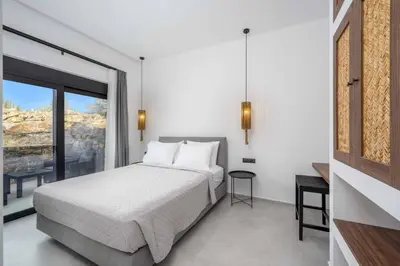 a bedroom with a bed and a large window at Villa Kiotari Star in Kiotari