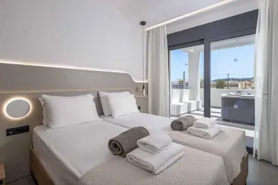 a bedroom with two beds and a large window at Villa Evelia in Ialyssos