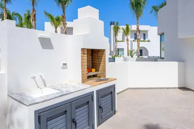 a white house with a kitchen with a fireplace at Villa Evelia in Ialyssos
