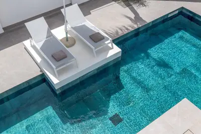 an overhead view of a pool with a chair and an umbrella at Villa Evelia in Ialyssos