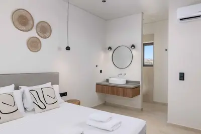 a bedroom with a bed with a sink and a mirror at Massari Hills Villa 9 in Malona Village